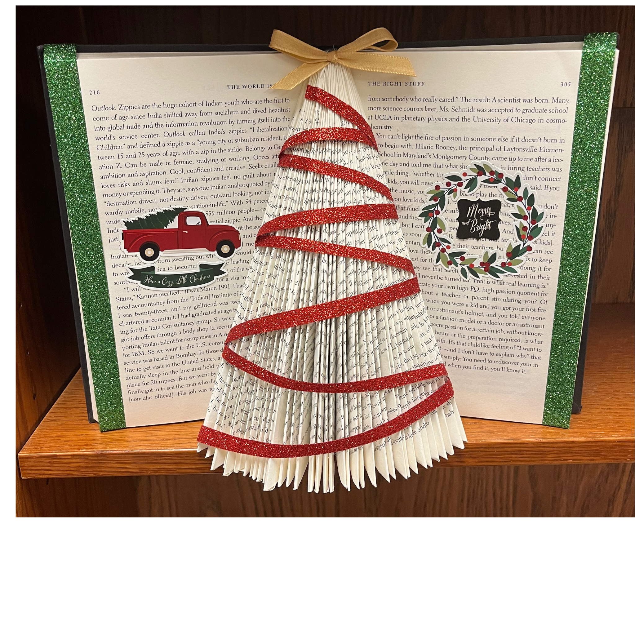 An old book with pages folded and decorated to look like a Christmas tree